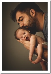 Newborn baby girl in his father's hands yawning