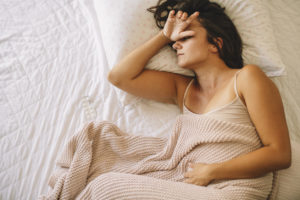 young woman in bed with menstrual pain